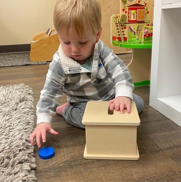 Infant playing with a toy bank